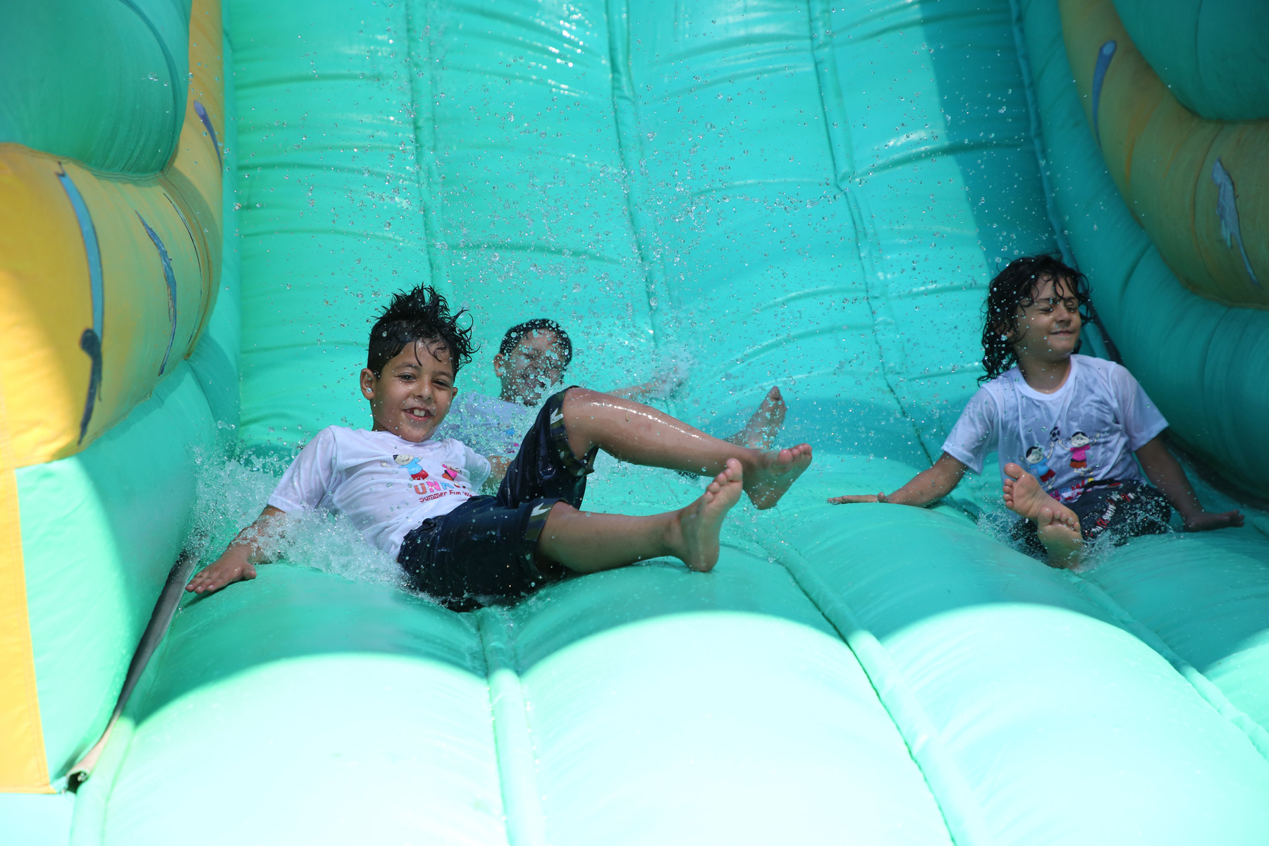 Children coming down an inflatable water slide