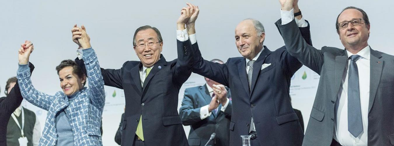 前秘书长潘基文（左二）、《气候公约》前执行主任克里斯蒂安娜•菲格雷斯（左一）、法国前外交部长兼巴黎联合国气候变化大会（缔约方会议第二十一届会议）主席洛朗•法比尤斯和法国前总统弗朗索瓦•奥朗德（右一）庆祝《巴黎协定》获得通过的历史性时刻。