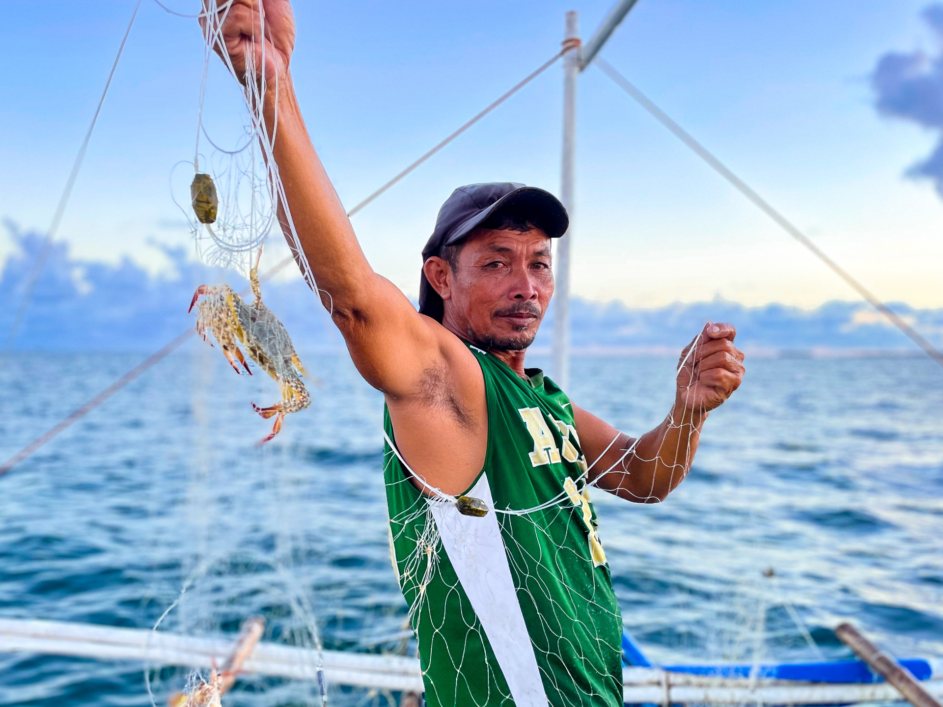 A fisherman catches crab in his net