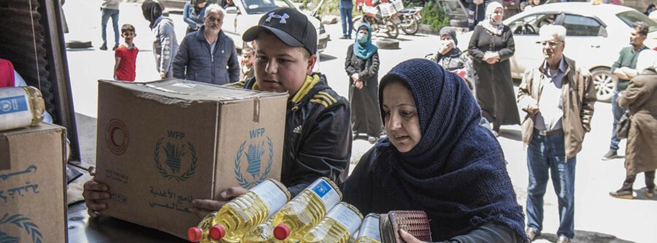  一个叙利亚家庭正在从世界粮食计划署的分发中心领取食物。