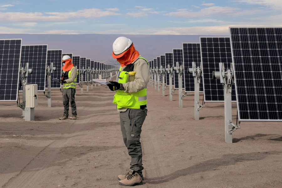 workers stand around solar panels