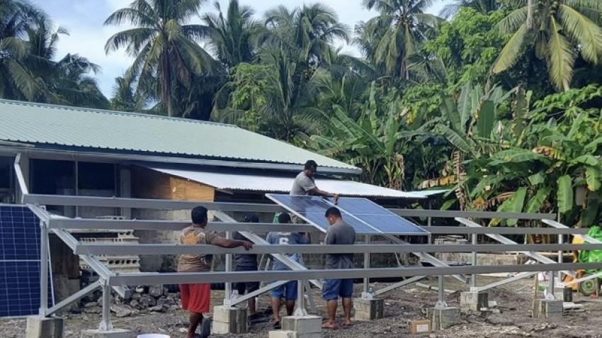 在帕劳，几位男性在安装太阳能电池板。可再生能源可能是确保国家福祉的关键。图片：帕劳教育部