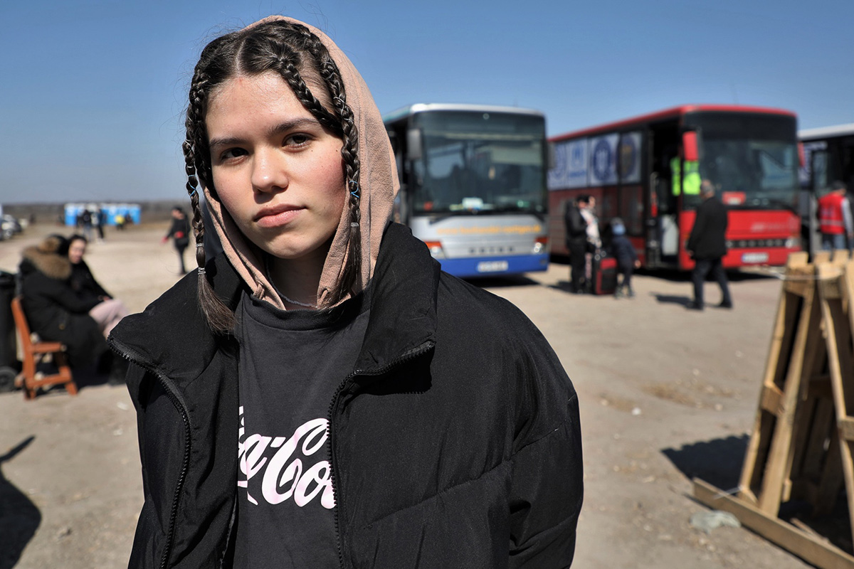 Portrait of a girl in front of parked buses