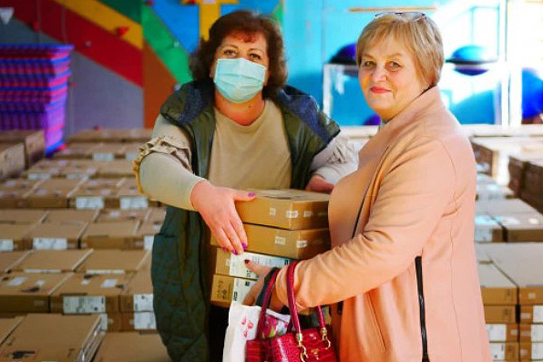 Two women carrying boxes
